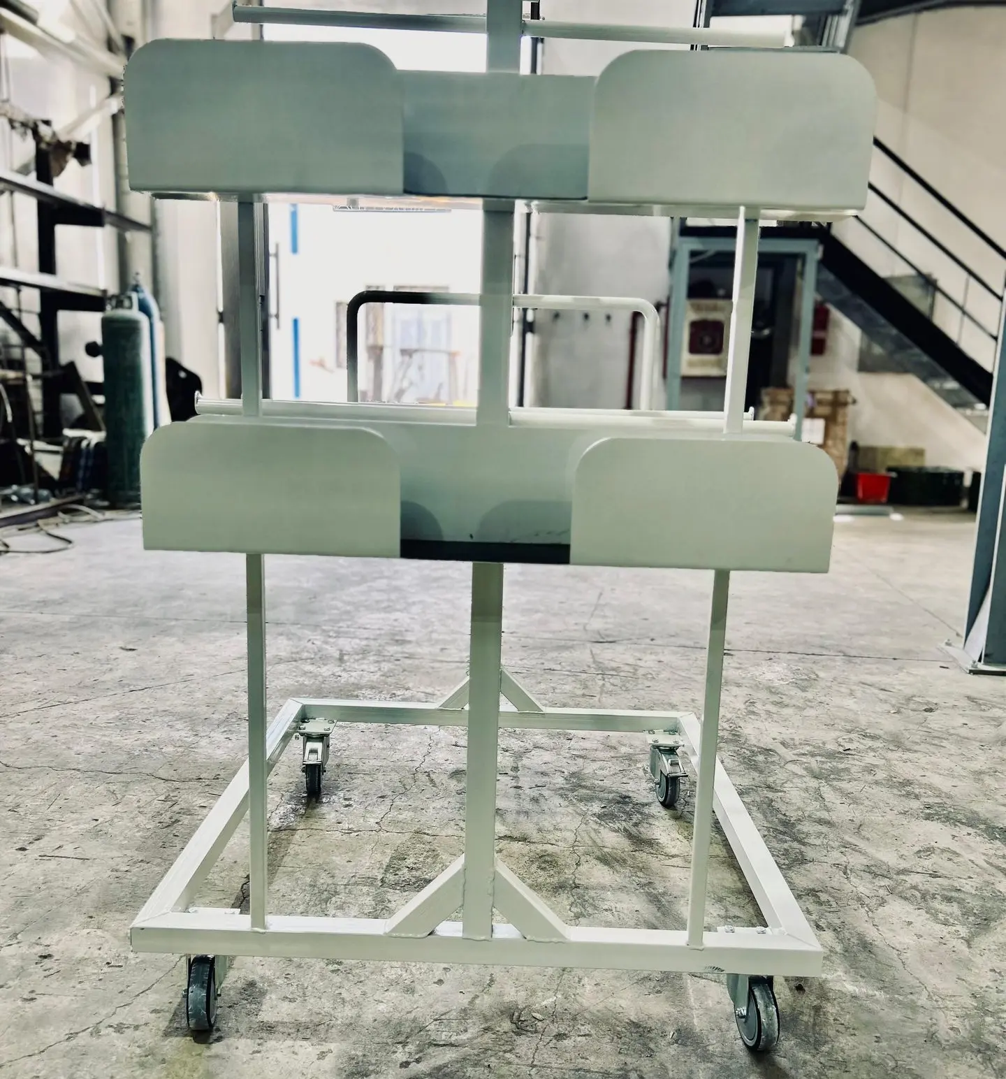 « Chariot de manutention avec plateforme tôlée, équipé de deux roulettes fixes et deux roulettes pivotantes. »